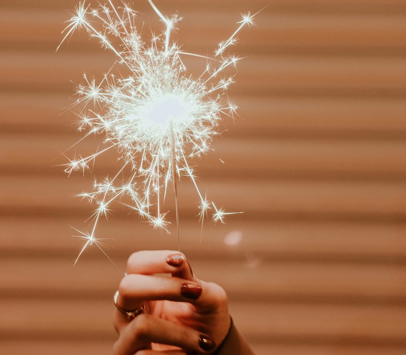 mano de chica con las uñas pintadas sujeta bengala encendida